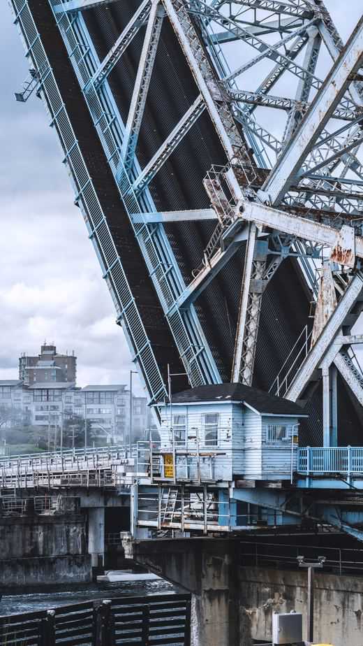 close up view of a drawbridge with a city in the background.