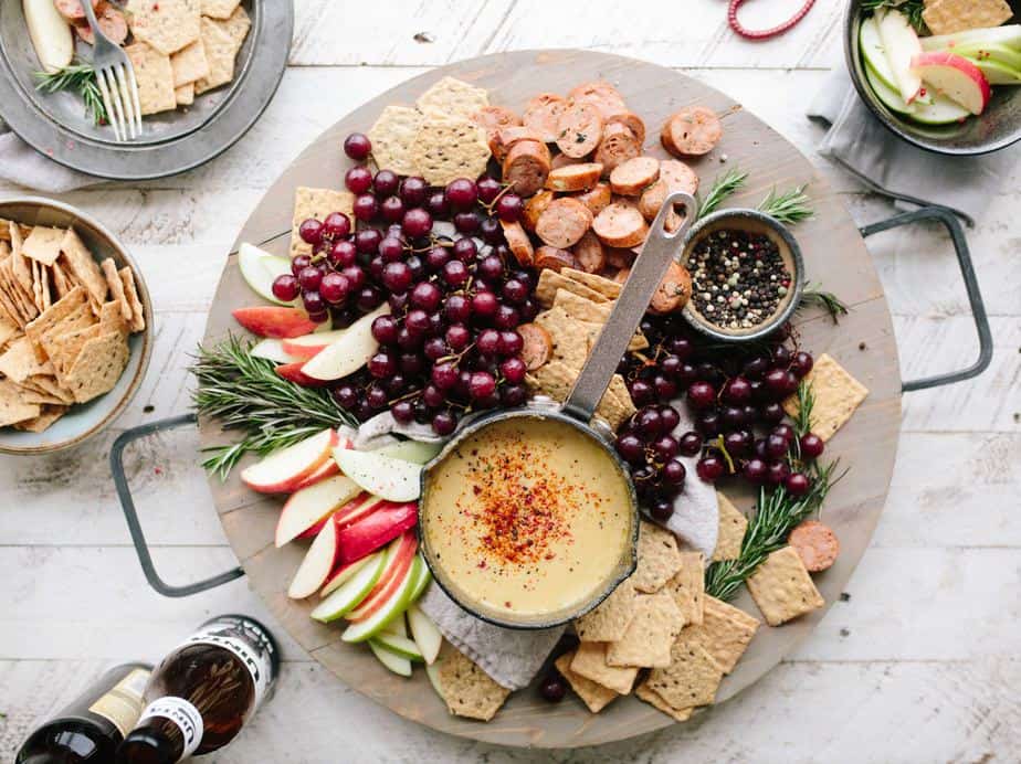 fruit,apple slices,crackers,and a sauce on a plate