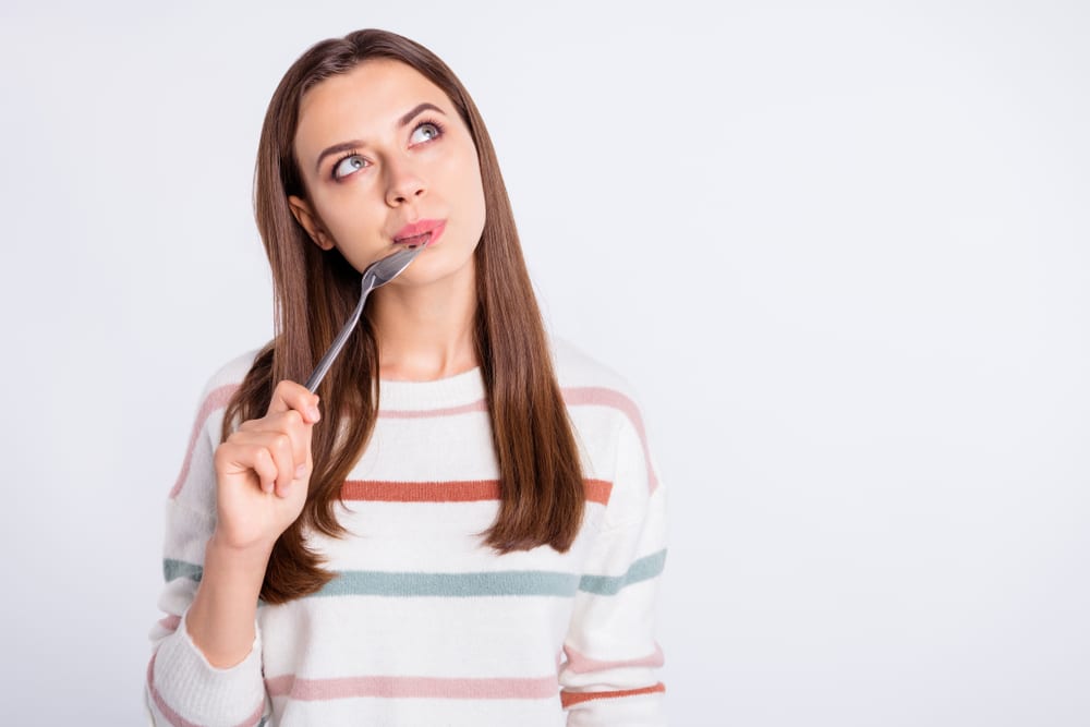 Hungry lady holding spoon Into mouth